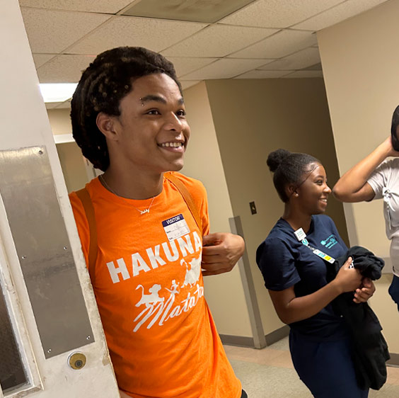 Jaysun Puryear smiling and wearing a shirt that says Hakuna Matata