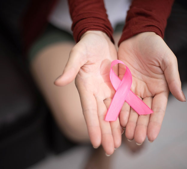 A pink ribbon in a woman's hand