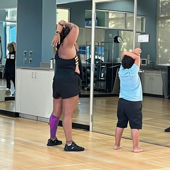 Meridith and Ossy stretch in front of a wall of mirrors at the Beaufort Memorial LifeFit Wellness Center.