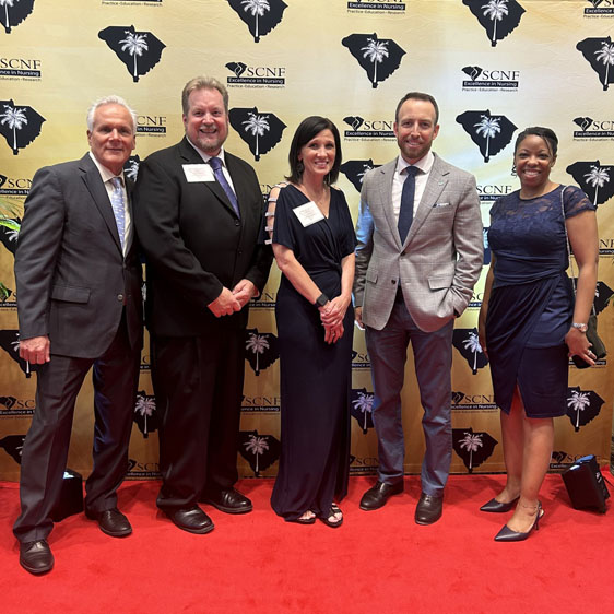 Group of BMH leaders pose in front of a banner at the Palmetto Gold Awards