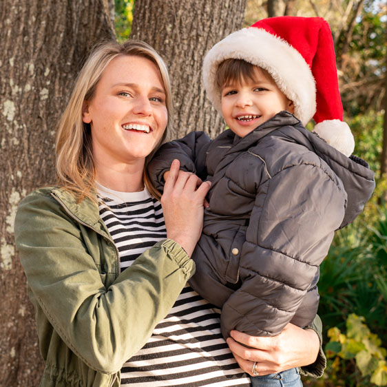 Photographer Charlotte Berkely holds her son, Berk, in front a tree