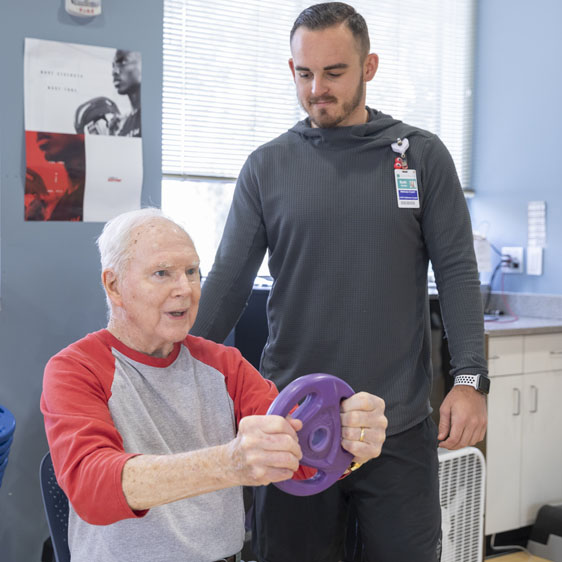 Bob Bergan working with weights during class