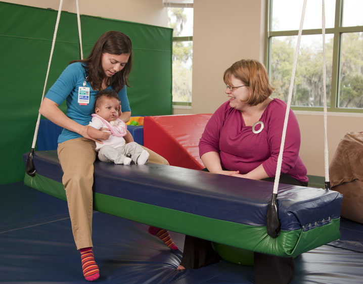 therapist with infant on a swing