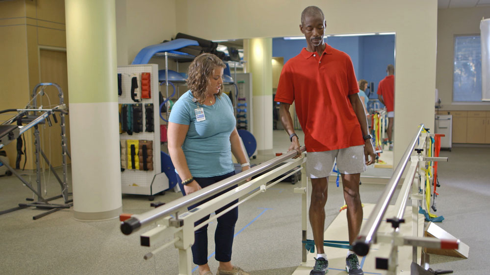 therapist working with a patient on leg exercise