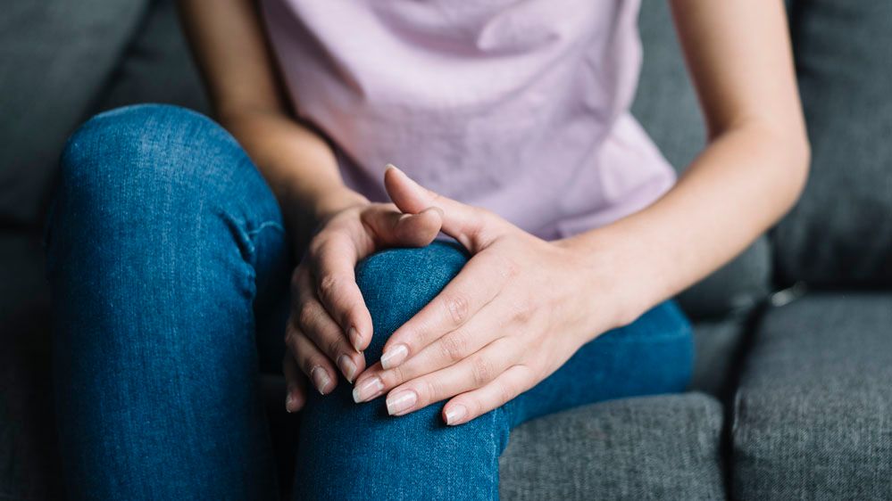 woman holding painful knee