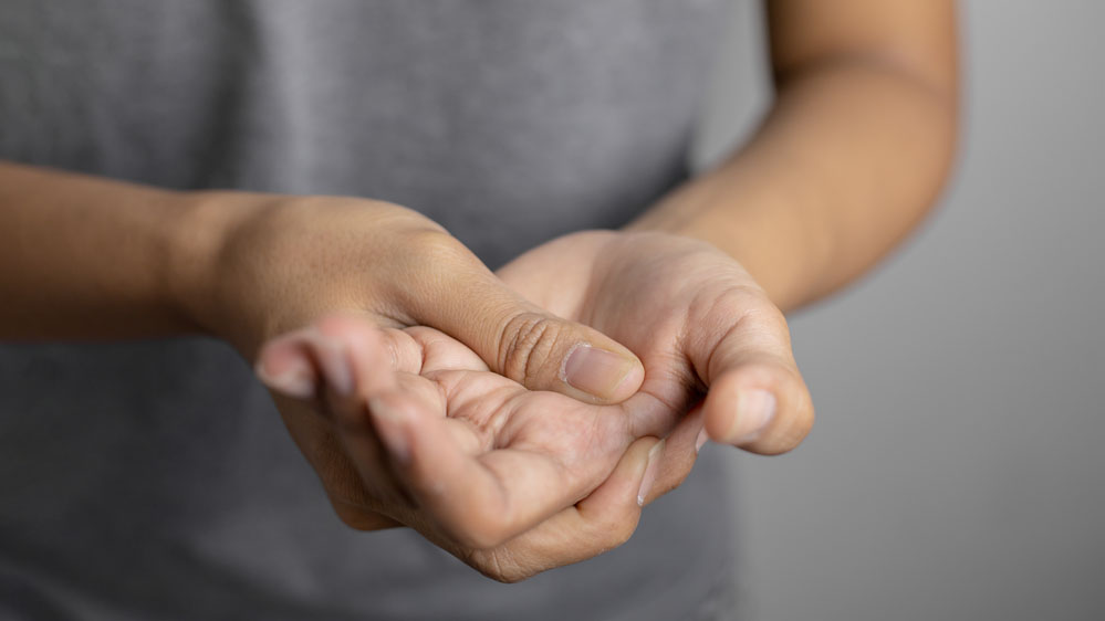 woman holding her painful hand