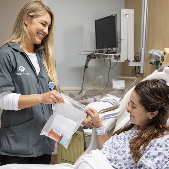 pharmacy tech delivering a prescription to a patient