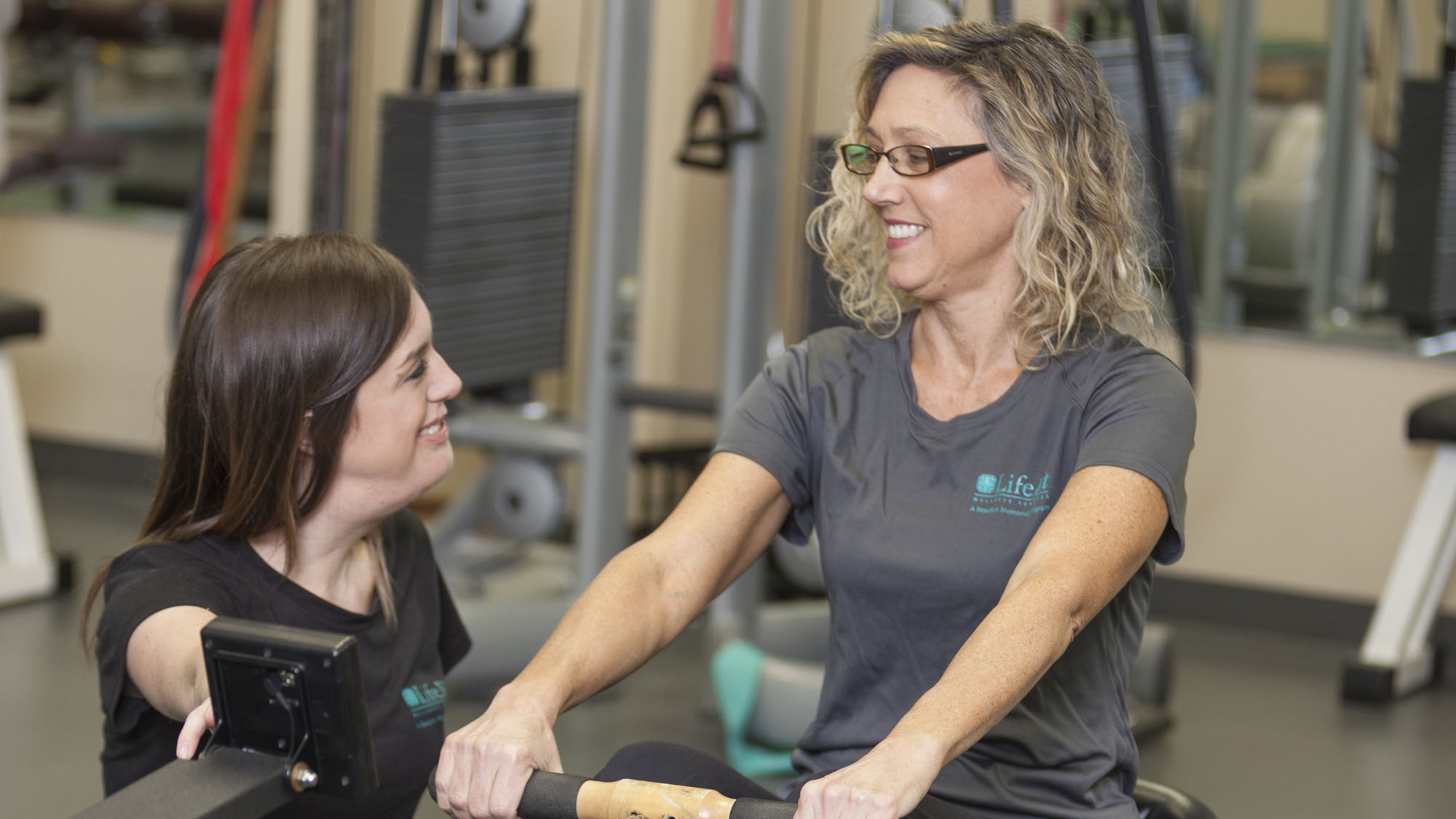 woman on a rowing machine working with a personal trainer