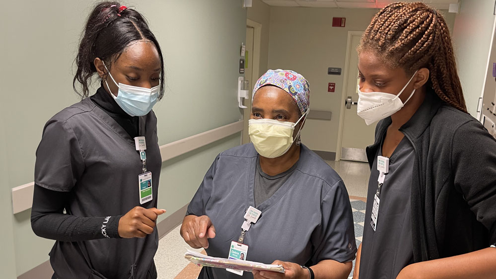 two whale branch students discuss care plan with nurse